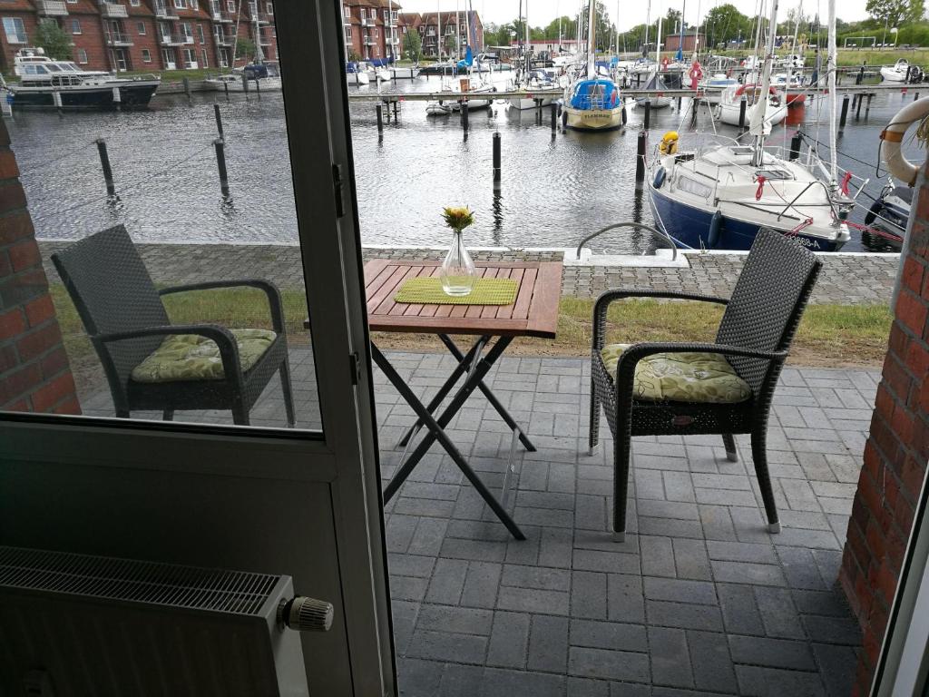 a table and chairs on a patio with a marina at FEWO-fuer-2-Pers-Hafenblick-2-Ueckermuende-Stettiner-Haff-Ostsee-direkt-Yachthafen in Ueckermünde