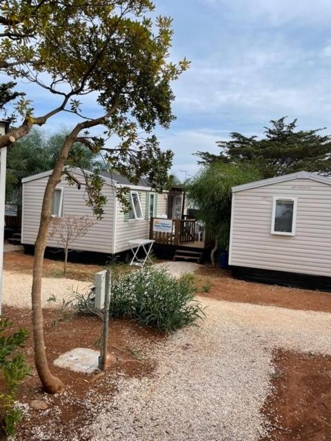 kilka przyczep mieszkalnych zaparkowanych obok domu w obiekcie Happy Camp mobile homes in Camping Villaggio Lamaforca w mieście Carovigno