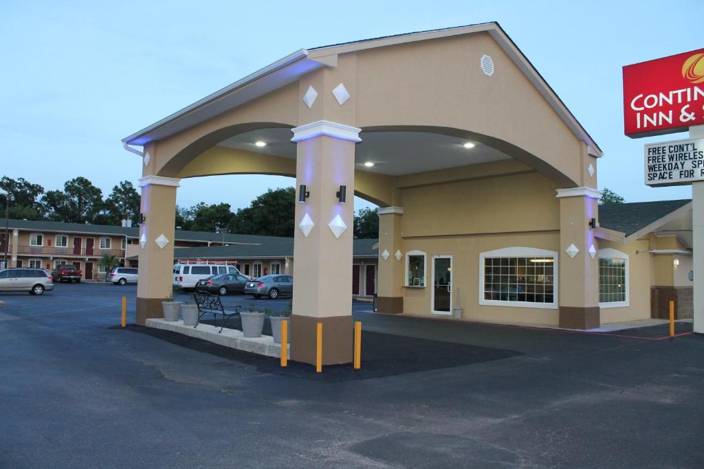 a building with a parking lot in front of it at Continental Inn and Suites in Nacogdoches