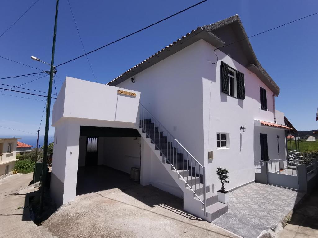 une maison blanche avec un escalier en face de celle-ci dans l'établissement Casa do Curral Velho, à Santana