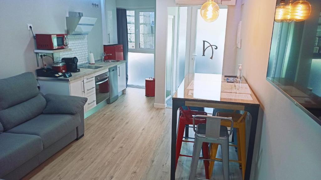 een keuken en een woonkamer met een bank en een tafel bij Alcazaba - Free Parking in Merida