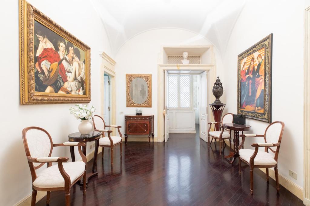 a room with chairs and paintings on the walls at iFlat Spanish Steps Luxury and Historical Apt in Rome