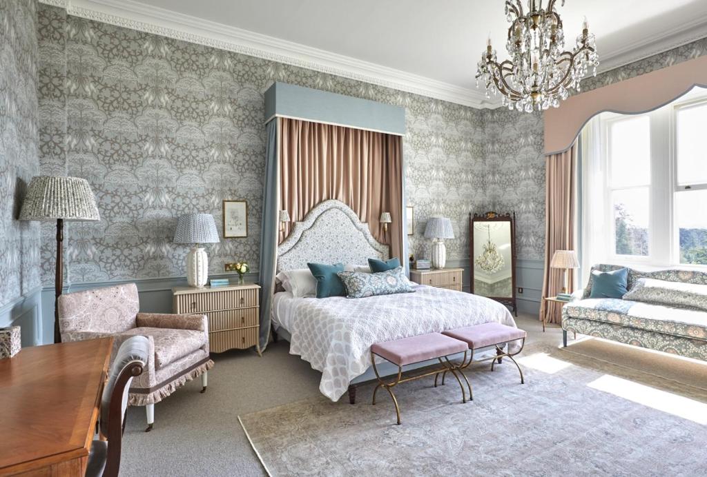 a bedroom with a bed and a table and a chair at Leonardslee House at Leonardslee Lakes & Gardens in Horsham