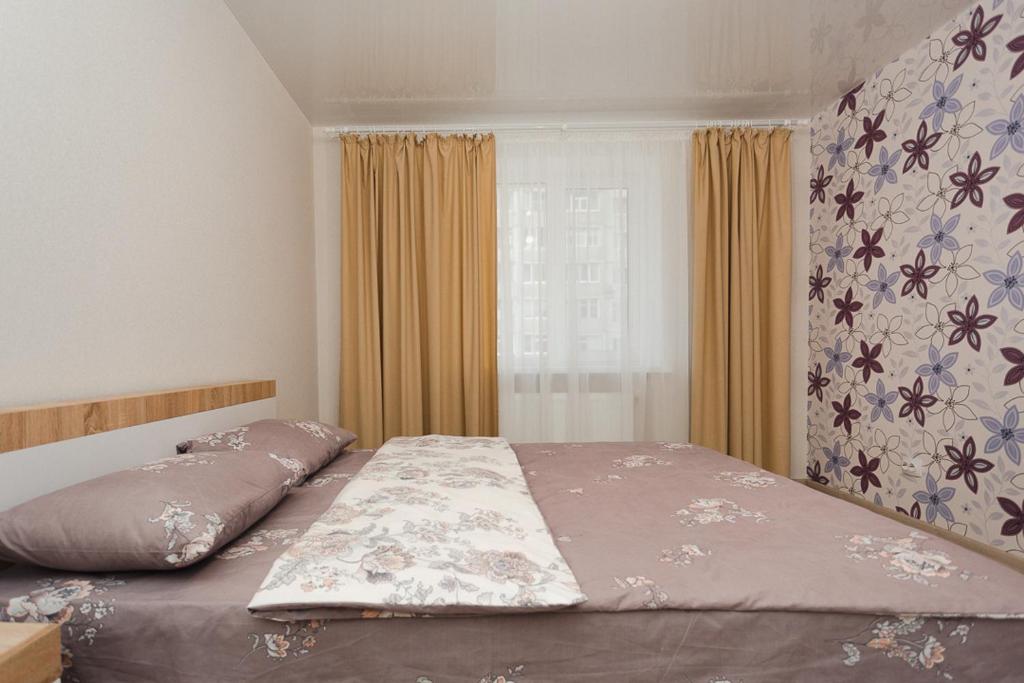 een slaapkamer met een bed en een raam bij Apart Prokof'yeva in Sumy