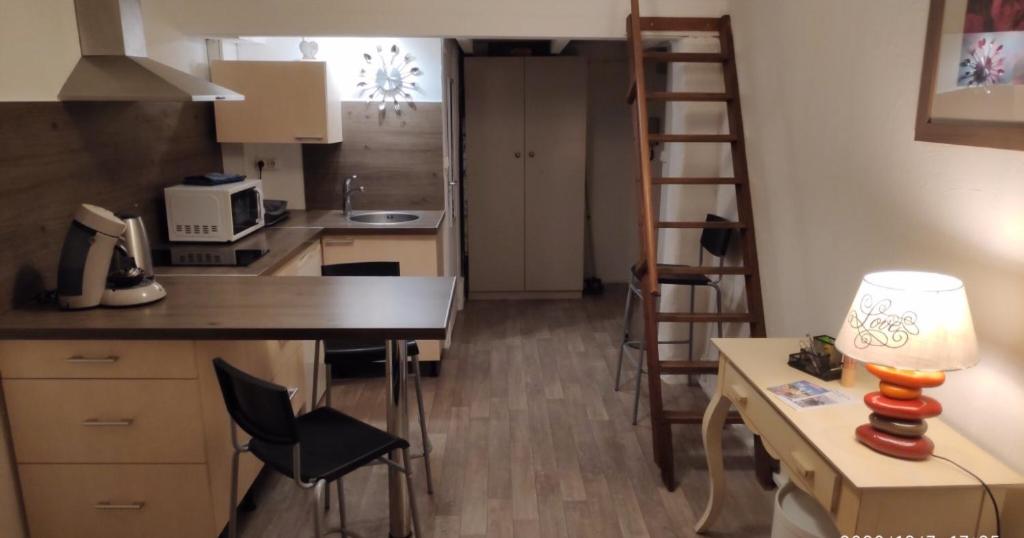 une petite cuisine avec un bureau et une échelle dans l'établissement Studio Avignon Intra Muros, à Avignon
