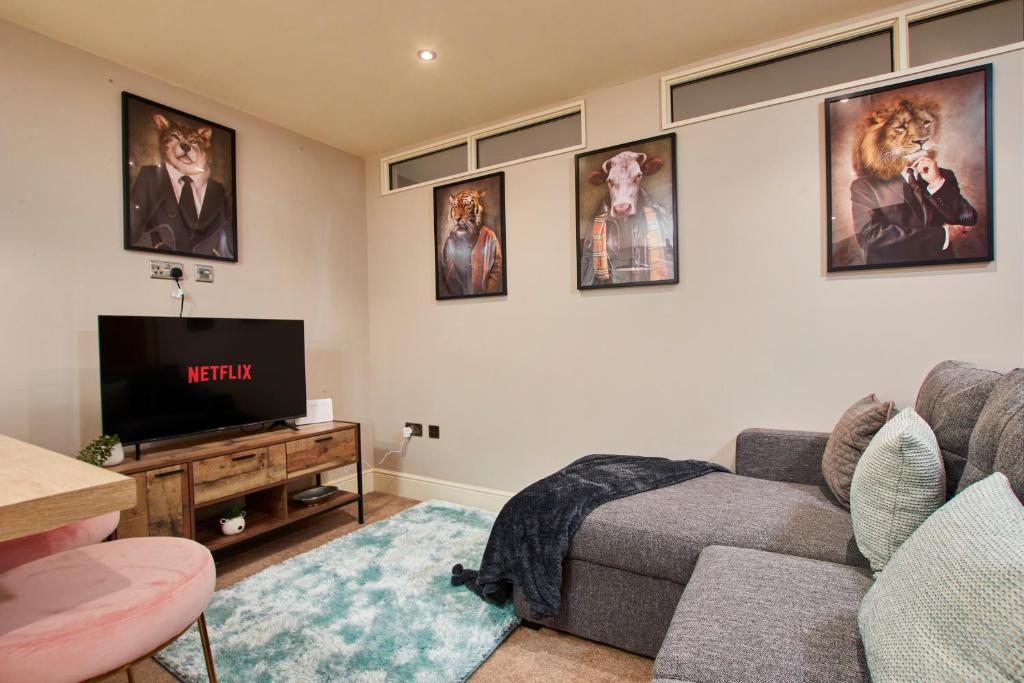 a living room with a couch and a flat screen tv at The Exquisite Harrogate Abode - Sleeps 6 in Harrogate