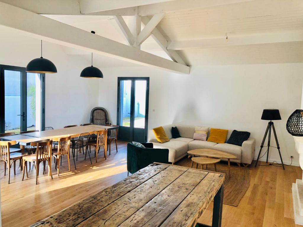 un salon avec une table et un canapé dans l'établissement Maison familiale, à 100 mètres plage., à La Couarde-sur-Mer
