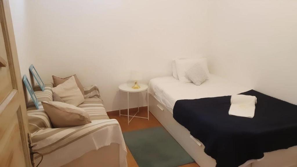a small room with a bed and a couch at Lanui Guest House in Sintra