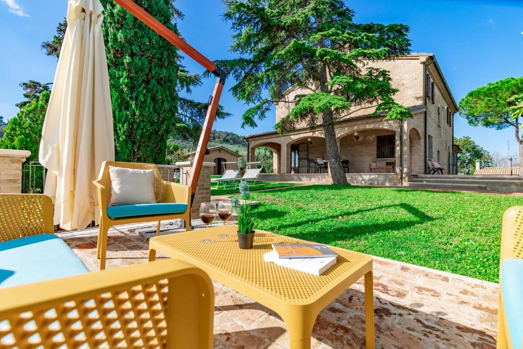 a patio with a table and chairs and a house at Italian Experience-Villa Vagnini in Pesaro