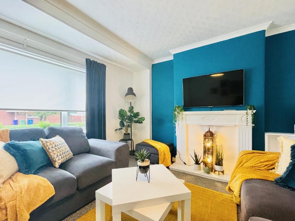a blue living room with a couch and a fireplace at Linburn House in Glasgow