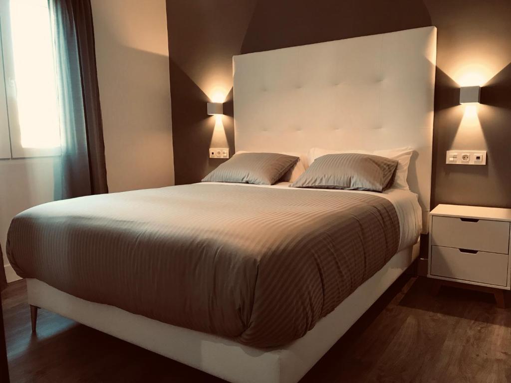 Apartamentos Ciudad de Ronda في روندا: غرفة نوم بسرير كبير مع وسادتين