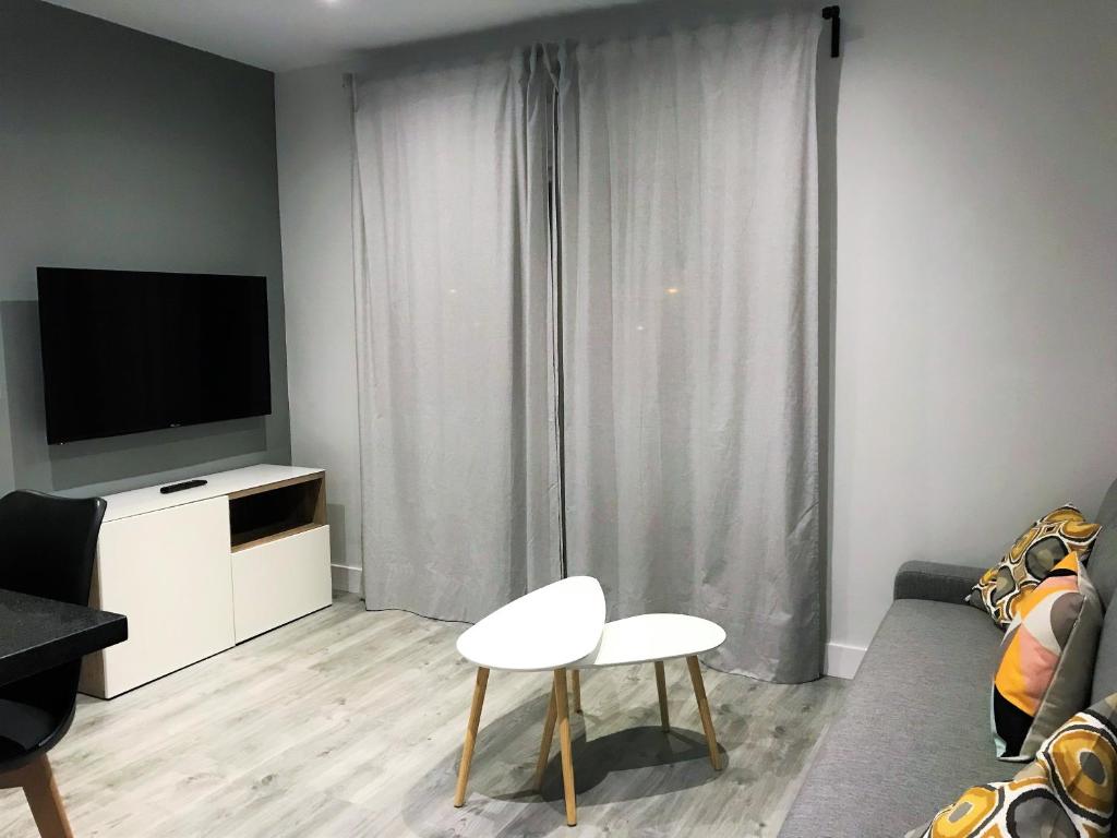 Televízia a/alebo spoločenská miestnosť v ubytovaní Apartamentos Ciudad de Ronda