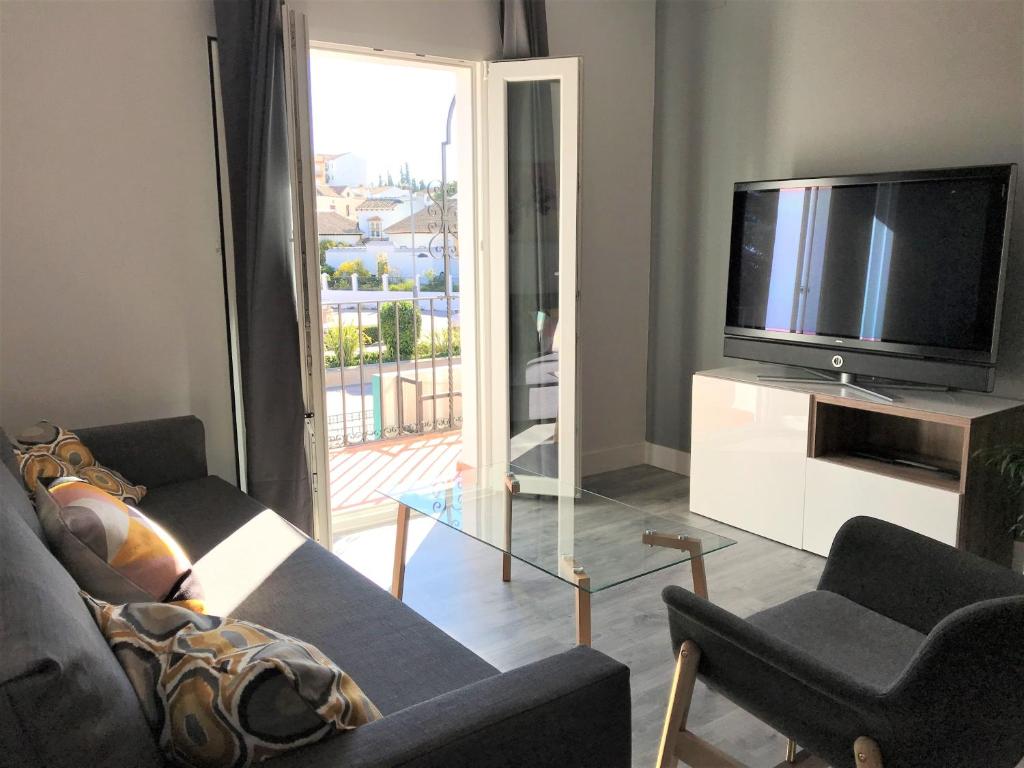 Televízia a/alebo spoločenská miestnosť v ubytovaní Apartamentos Ciudad de Ronda