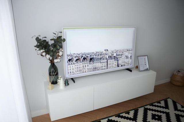 einen Fernseher auf einem weißen Stand in einem Wohnzimmer in der Unterkunft Vytautas Park Apartment in Marijampolė