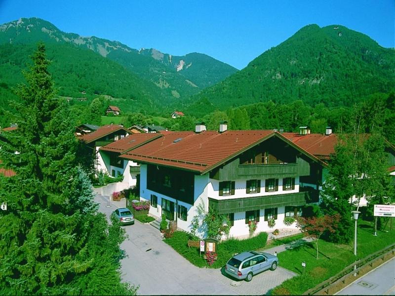 a large house with cars parked in a parking lot at Ferienwohnanlage Hochgern in Unterwössen