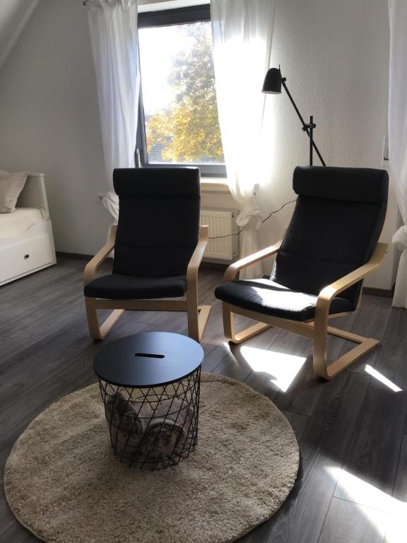 2 Stühle und ein Tisch im Wohnzimmer in der Unterkunft Apartment in der Waldstraße in Vellberg