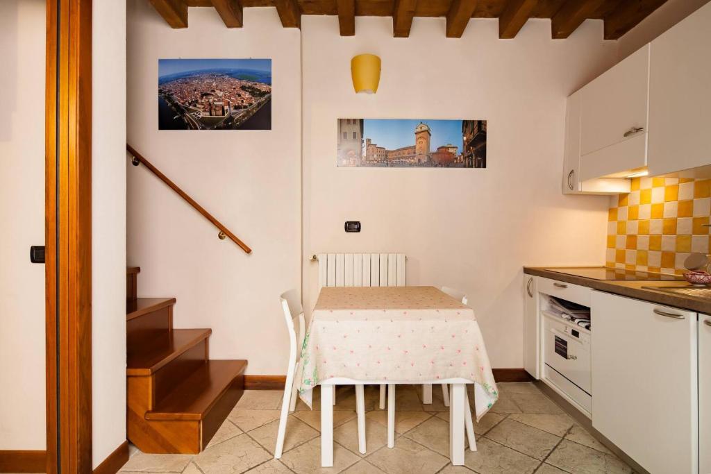 eine Küche mit einem Tisch, einem kleinen Tisch und Stühlen in der Unterkunft BellaMantova 3 in Mantua