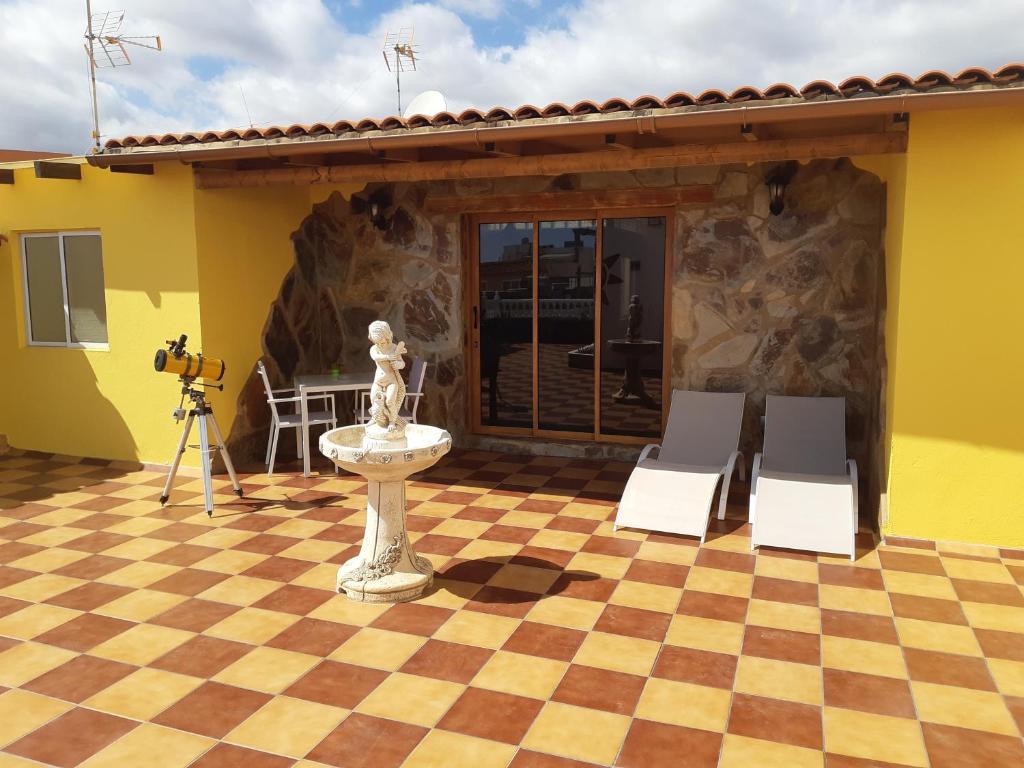 Cette chambre offre une vue sur un patio doté de 2 chaises et d'une fontaine. dans l'établissement Casa Guanche, à Cruce de Arinaga