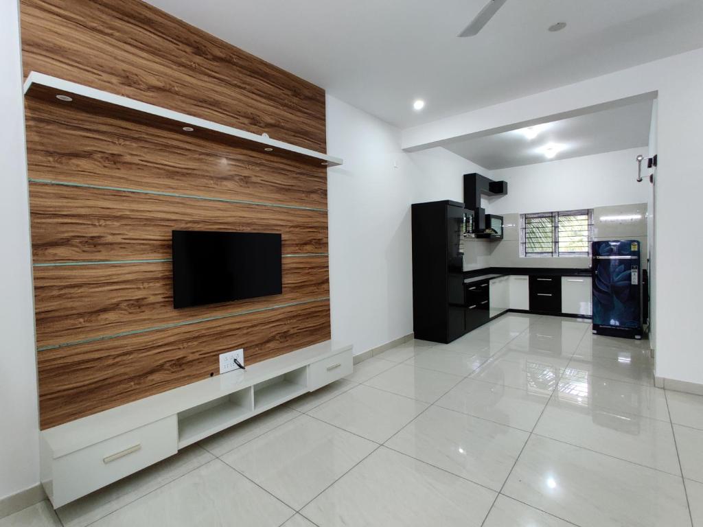 sala de estar con TV en la pared en SS LUXURY Comforts-Two bedroom en Chikmagalūr