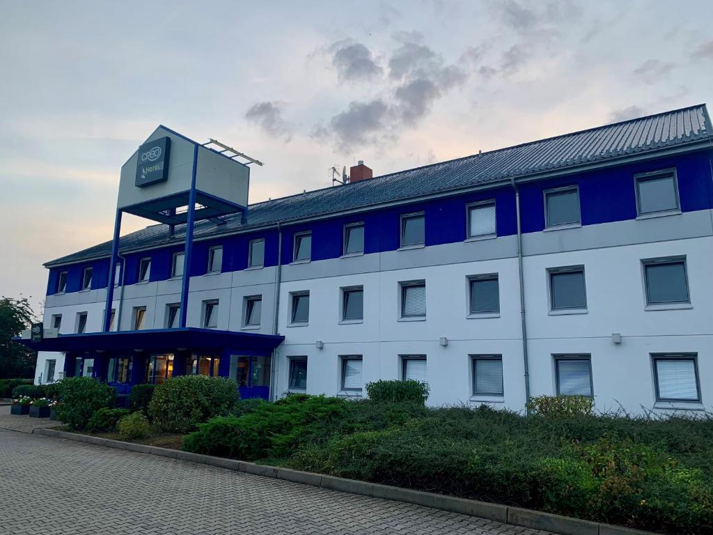 a large white building with a clock tower on top at CREO Hotel Dessau in Dessau