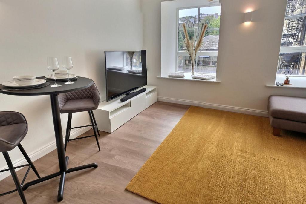 a living room with a table and a television at Haworth Hideaway in Haworth