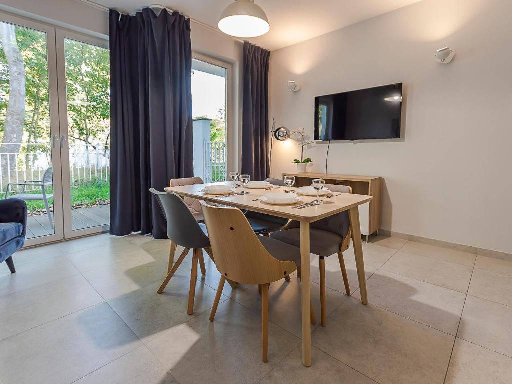 a dining room with a wooden table and chairs at VacationClub – Orłowska Riwiera Apartament B2 in Gdynia