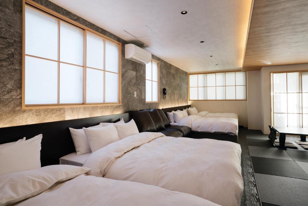 a room with a bunch of beds in it at Weskii Hotel in Kanazawa