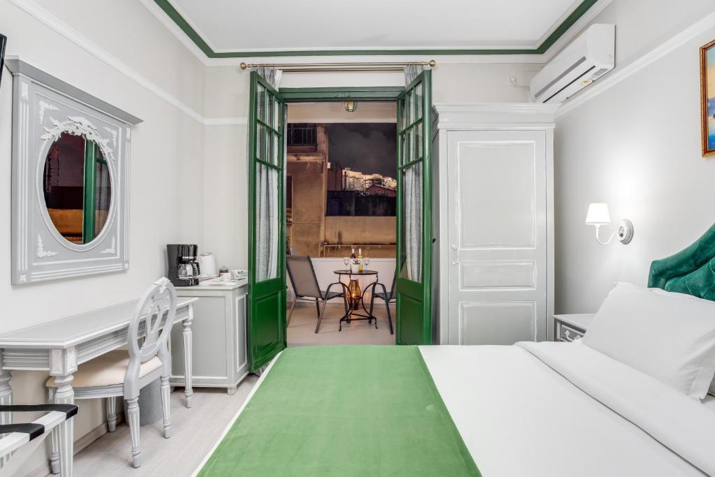 een slaapkamer met een groen bed en een tafel bij Pandrosos Divine Suites in Athene