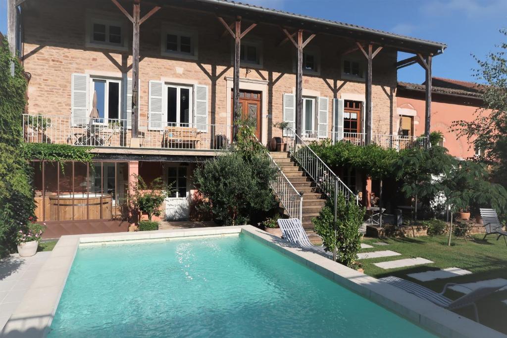 a house with a swimming pool in front of a house at La petite madeleine - Chambre d'hôtes & spa in Burgy