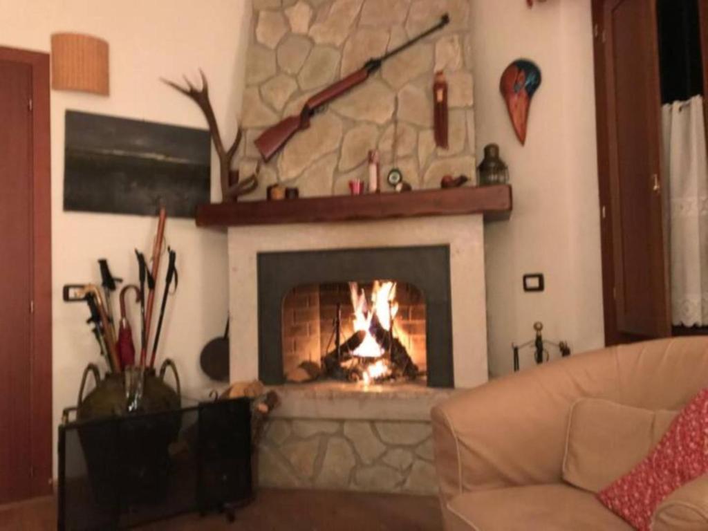 a fireplace in a living room with a fire place at Casa Val di Rose in Civitella Alfedena