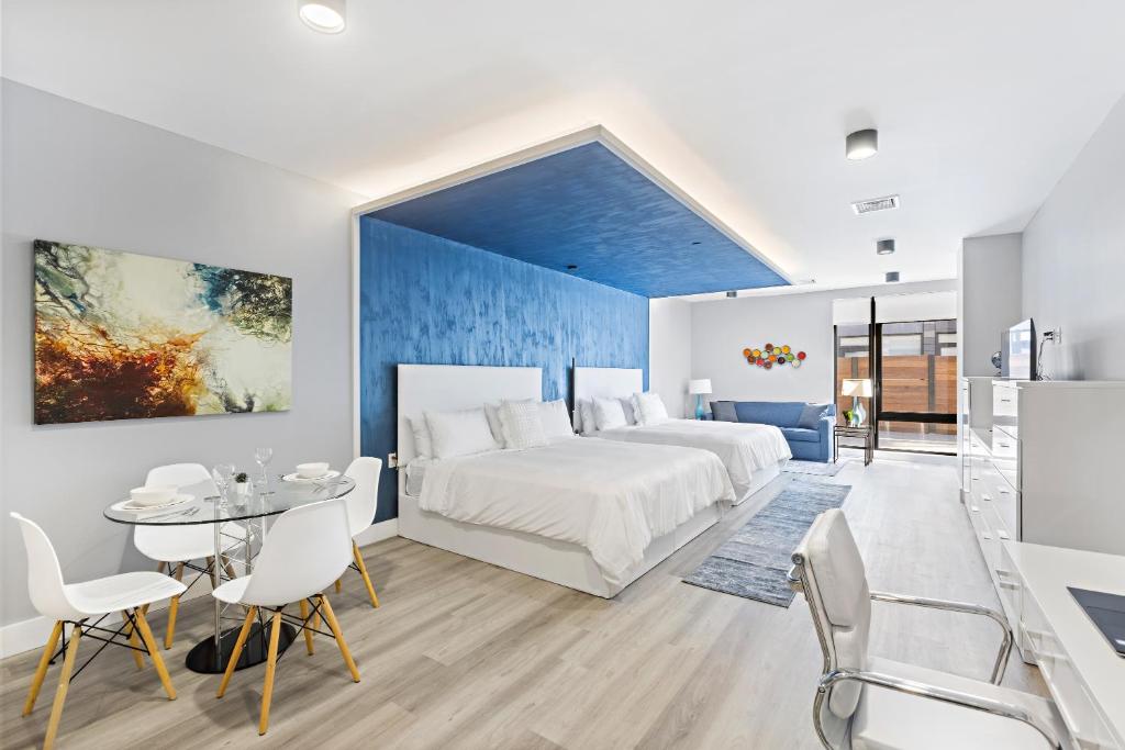 una camera con un letto bianco e una parete blu di Global Luxury Suites at The Arches a Bronx