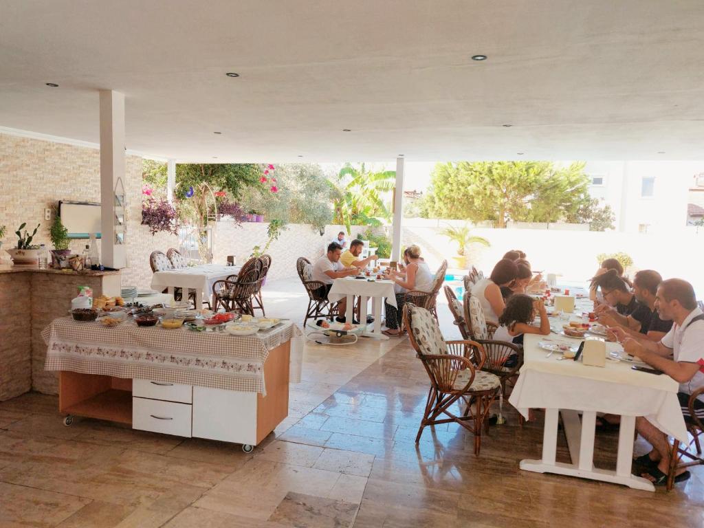 un groupe de personnes assises à table dans un restaurant dans l'établissement Eser Apart Dalyan, à Ortaca