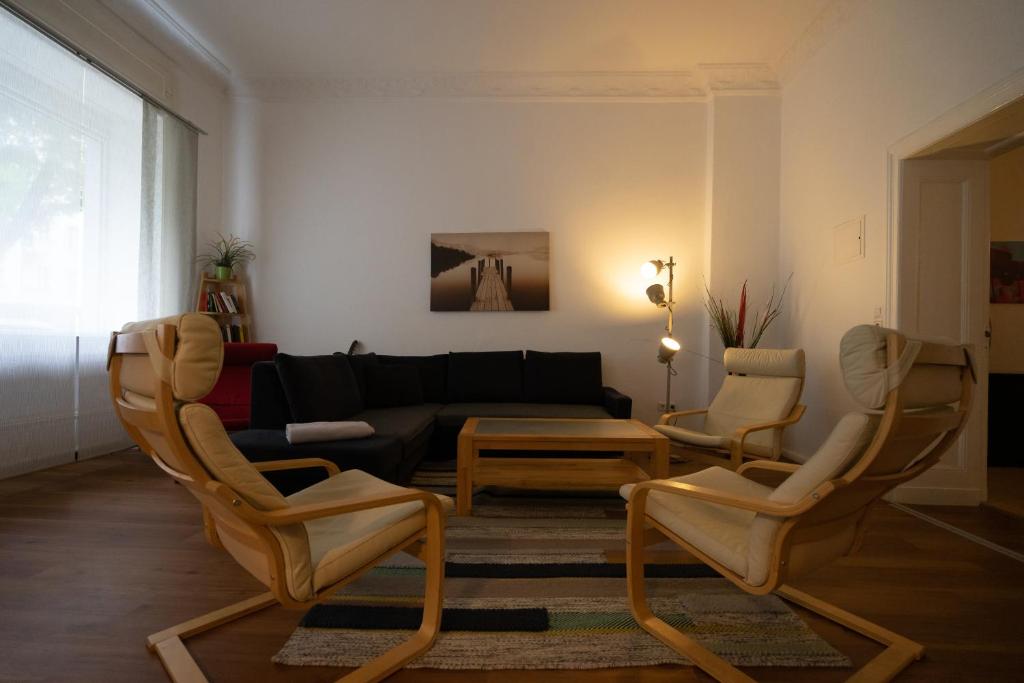 ein Wohnzimmer mit 2 Stühlen und einem Sofa in der Unterkunft Großes Apartment in zentraler Lage in Berlin