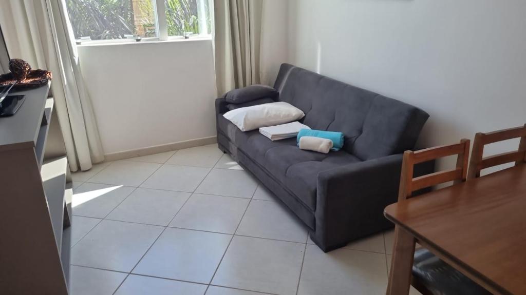 a living room with a black couch and a table at Condominio Barretos Thermas Park - Condohotel in Barretos