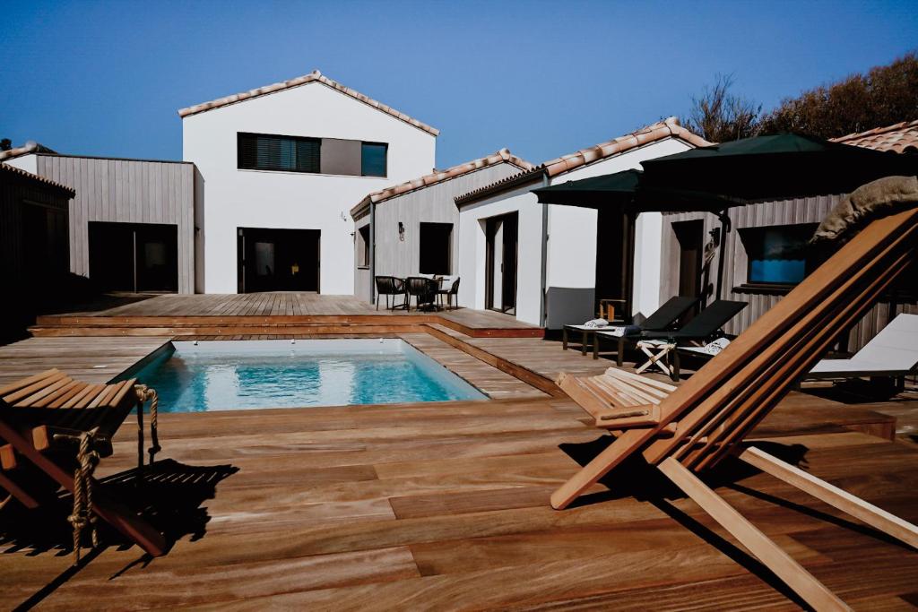 a backyard with a swimming pool and a house at L'envie in Saint-Gilles-Croix-de-Vie