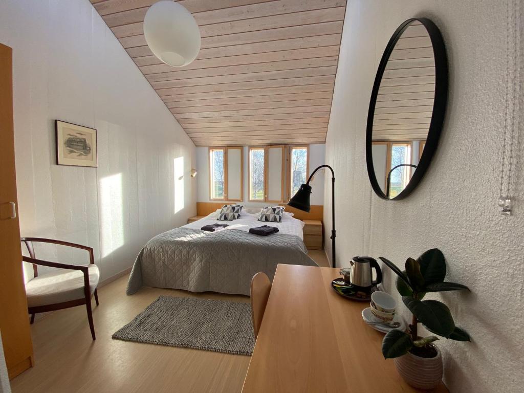 1 dormitorio con cama, mesa y espejo en Hótel Skálholt en Skálholt