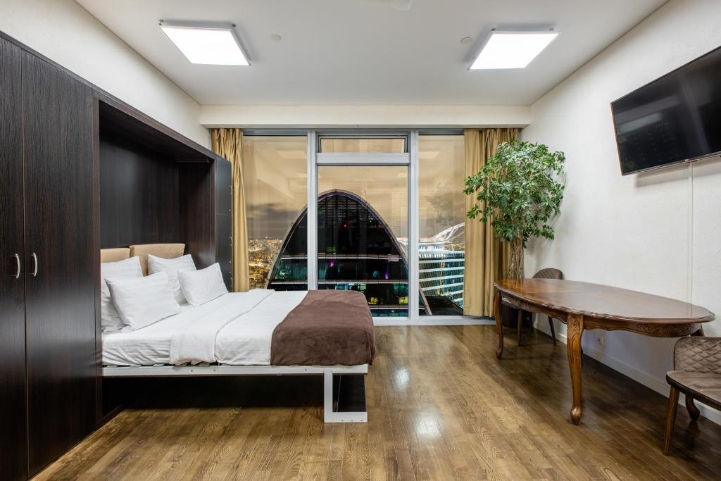 モスクワにあるRockmond 60 Junior Suiteのベッドルーム1室(ベッド1台、テーブル、窓付)