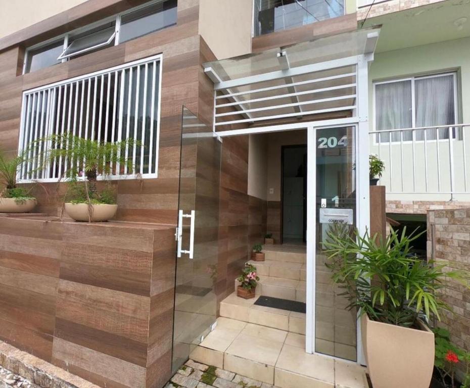 une maison avec une porte en verre devant elle dans l'établissement Hostel caminho da Cachoeira, à Florianópolis