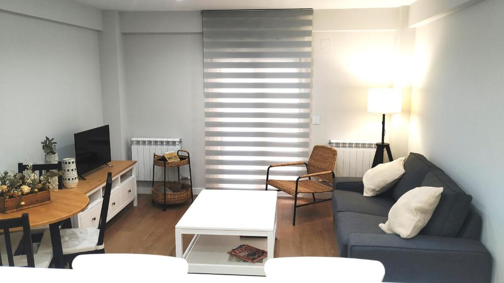 een woonkamer met een blauwe bank en een tafel bij VuT BALBOA APARTAMENTO in Salamanca