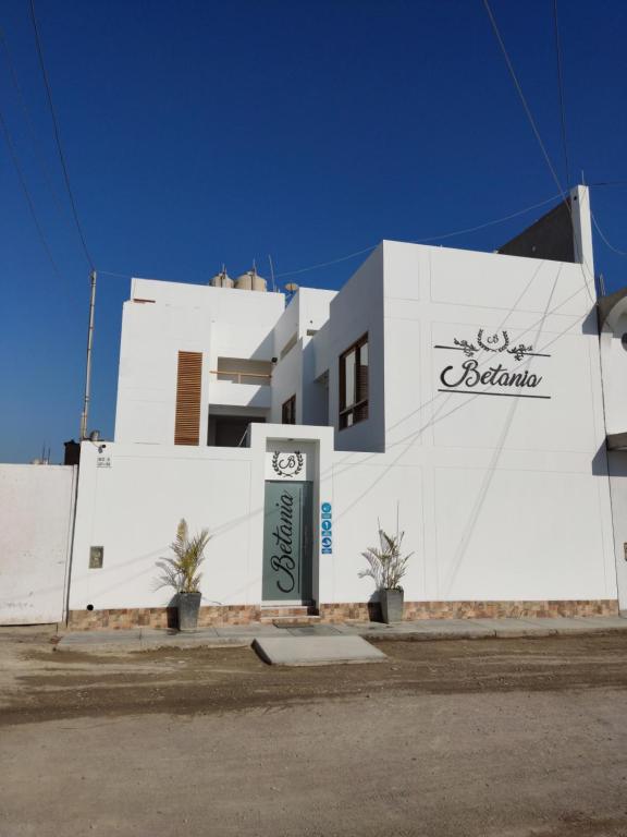 a white building with a sign in front of it at Betania in Paracas