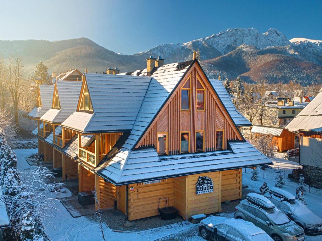 ein Haus mit einem Gameradach im Schnee in der Unterkunft Etiuda Zakopane in Zakopane