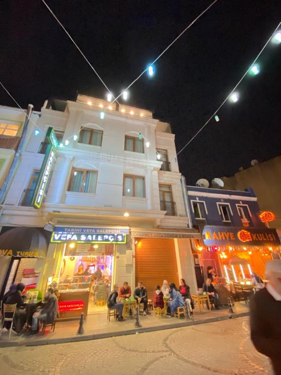 a group of people sitting outside of a building at night at RENOVA TURiZM HOTEL in Istanbul