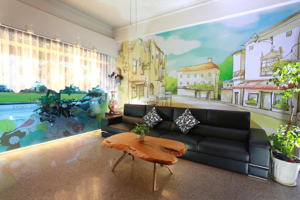 a living room with a couch and a painting on the wall at Xiang Heng House in Luodong