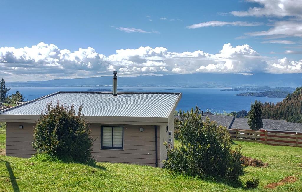 ein Haus auf einem Hügel mit Blick auf das Wasser in der Unterkunft Cabaña Puro Ranco in Lago Ranco