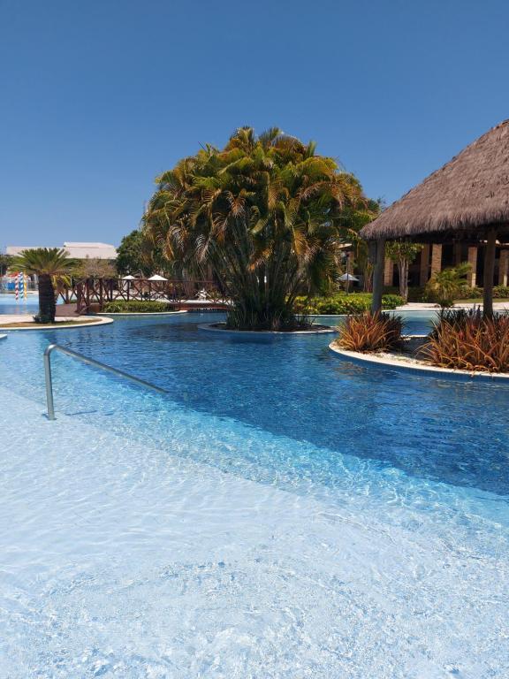 uma piscina com água azul num resort em Iloa Prime 103 V em Barra de São Miguel