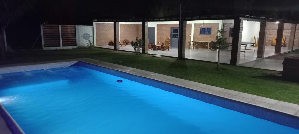 a swimming pool at night with blue lights at Cabañas El Kincho in Albardón