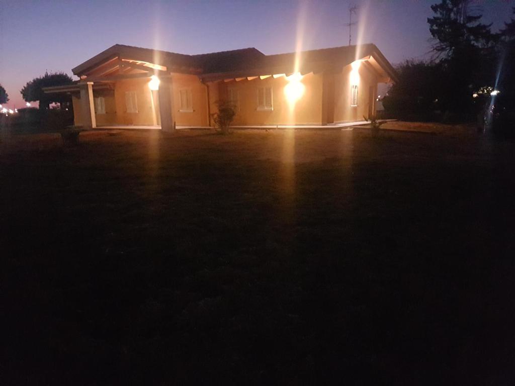 una casa iluminada por la noche con luces en Mazzi House Garden en Dossobuono