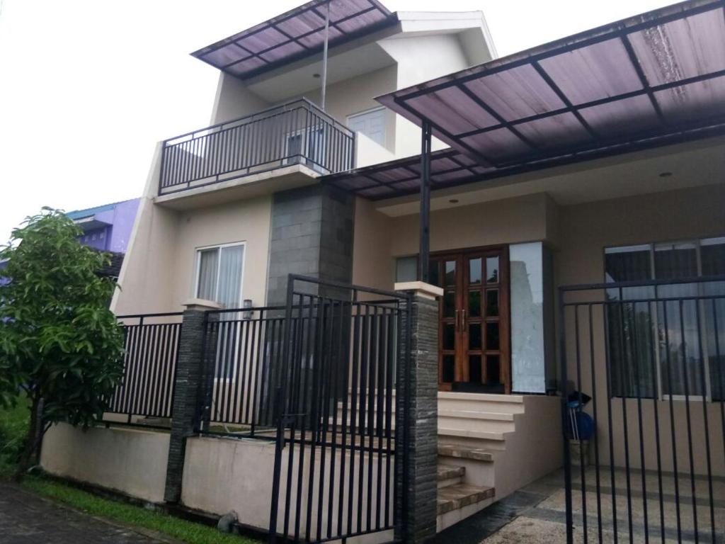 ein Haus mit einem Balkon und einem Zaun in der Unterkunft Villa Batu Iggy in Batu