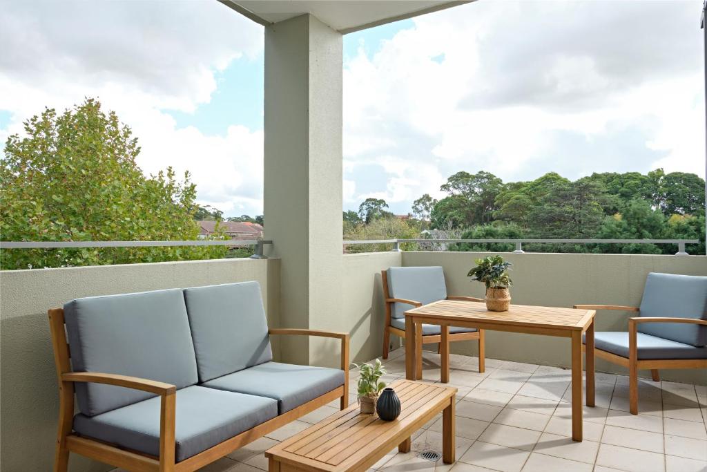 balcón con sillas, mesa y ventana en Warrawee Premium 2 Bed Apartment w Large Balcony and Secure Parking en Warrawee