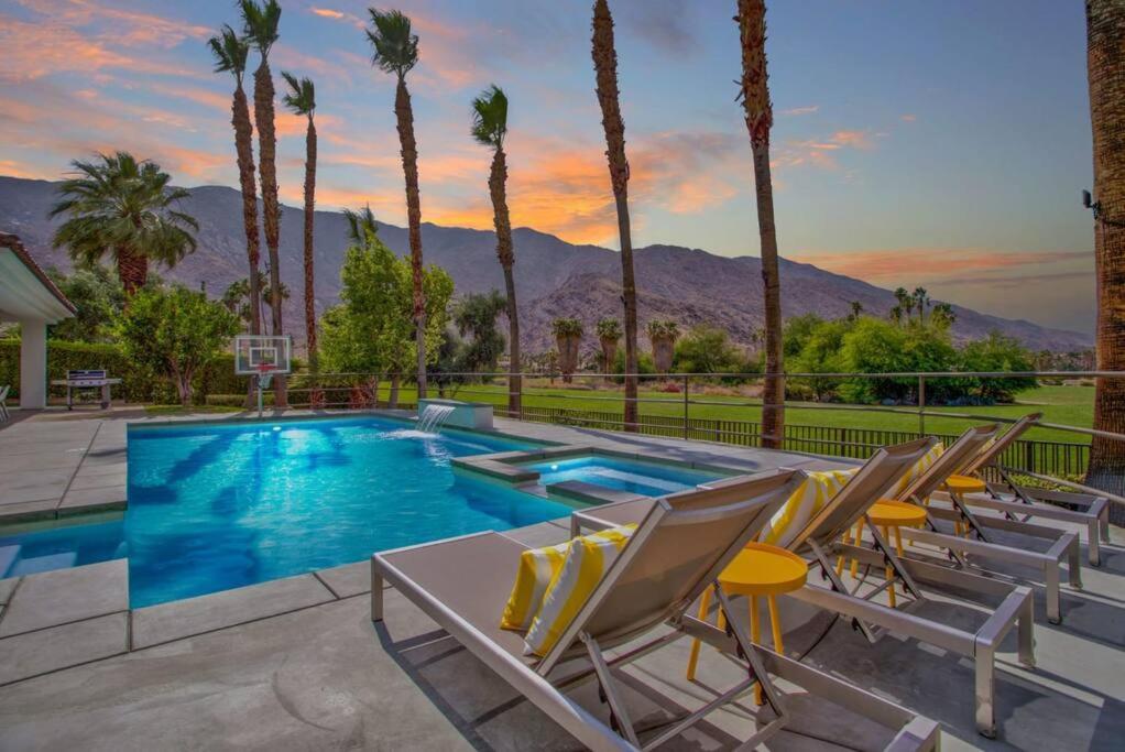 a swimming pool with chairs and a basketball hoop at Luxury Palm Springs Retreat w/ Heated Pool & Spa in Palm Springs